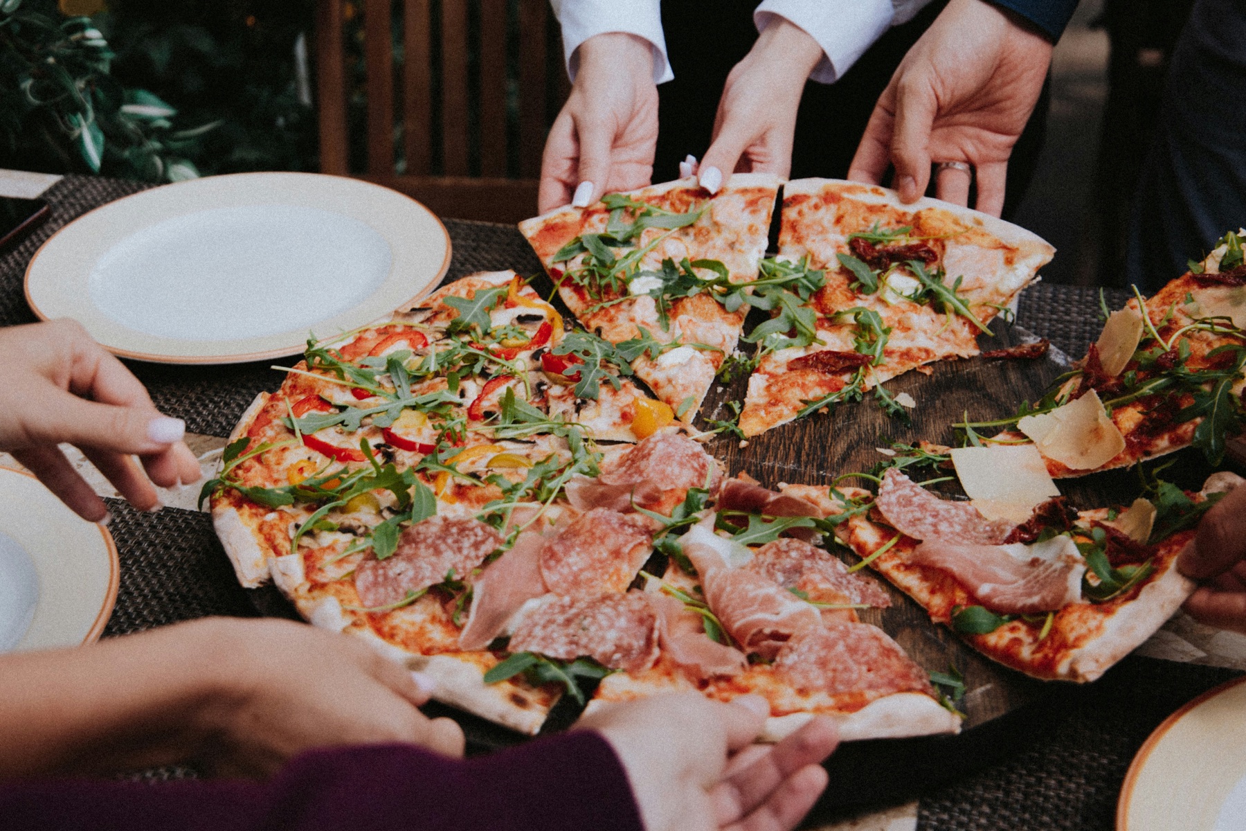 Guests sharing a selection of freshly cooked pizzas